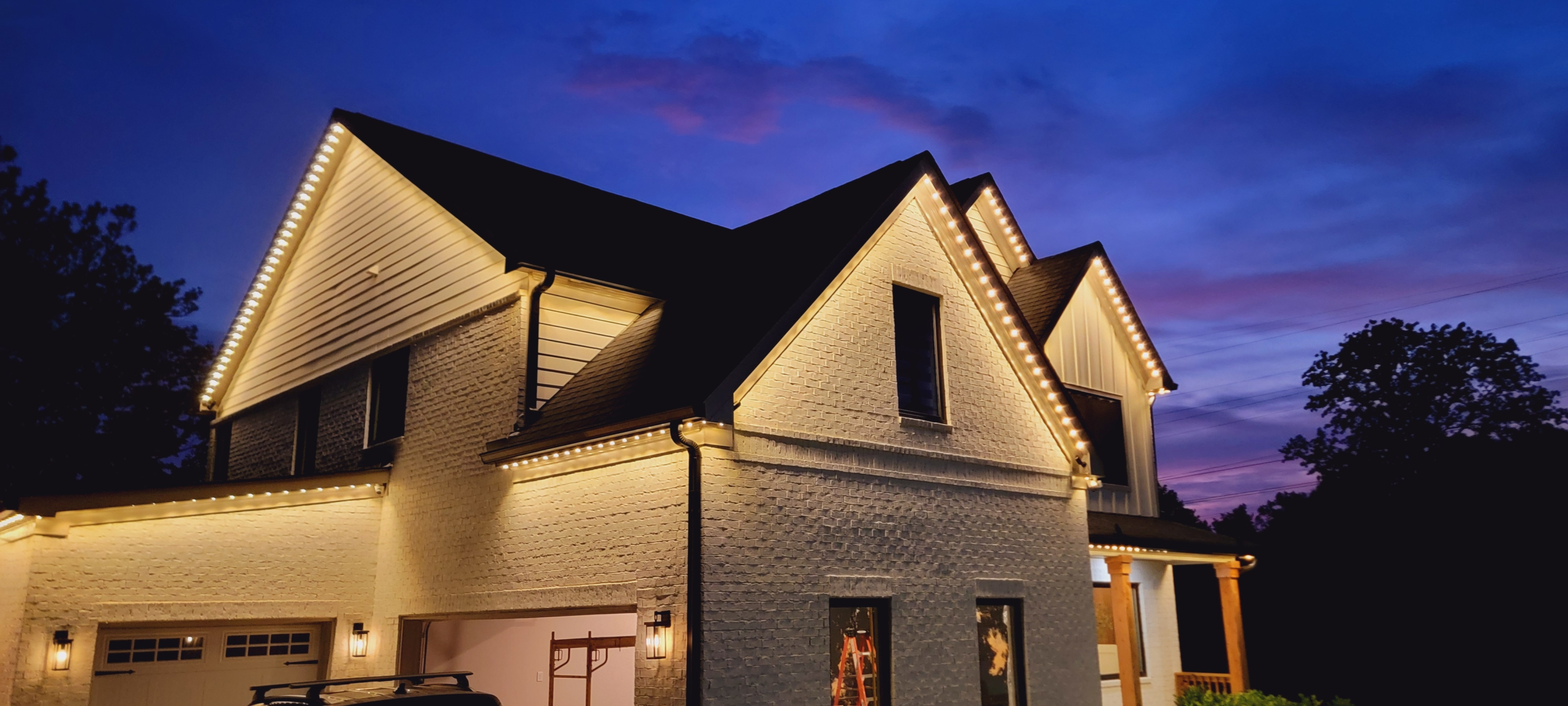 Warm white permanent roofline lighting installed on a home by Light Up Lima